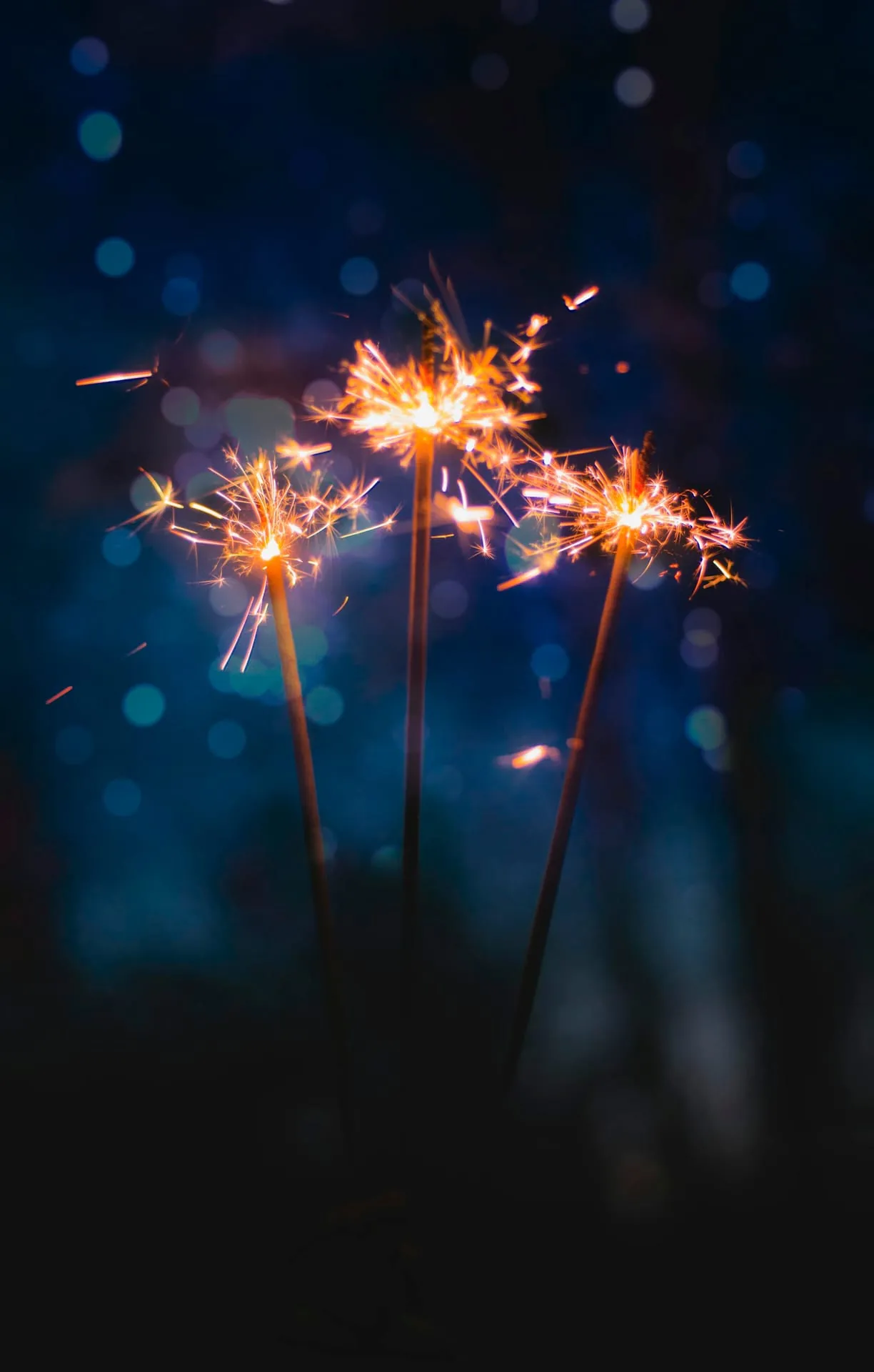 Three sparklers blue bokeh celebration