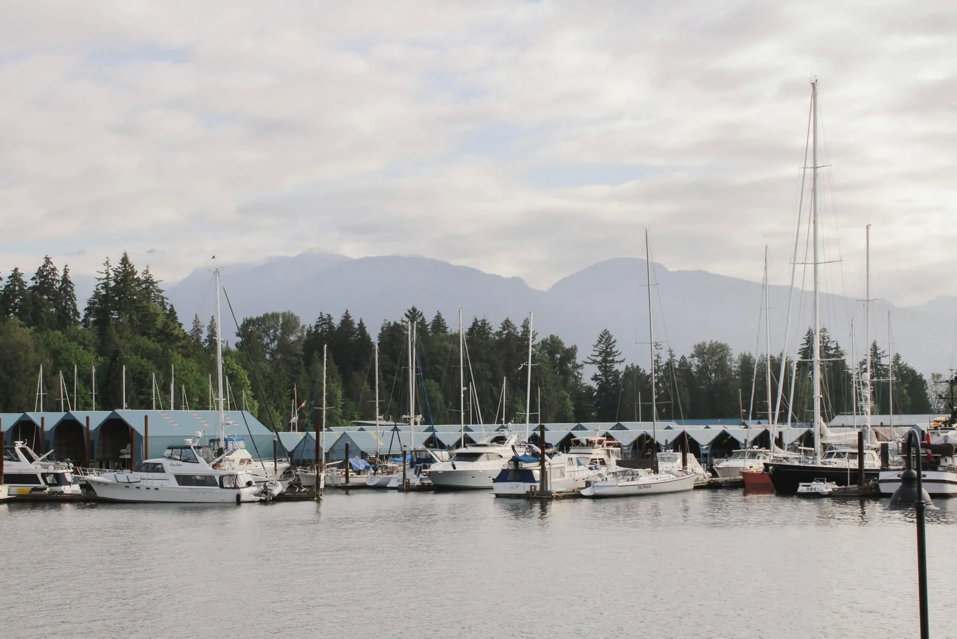 Coastal Northern BC marina with sailboats beneath overcast mountains