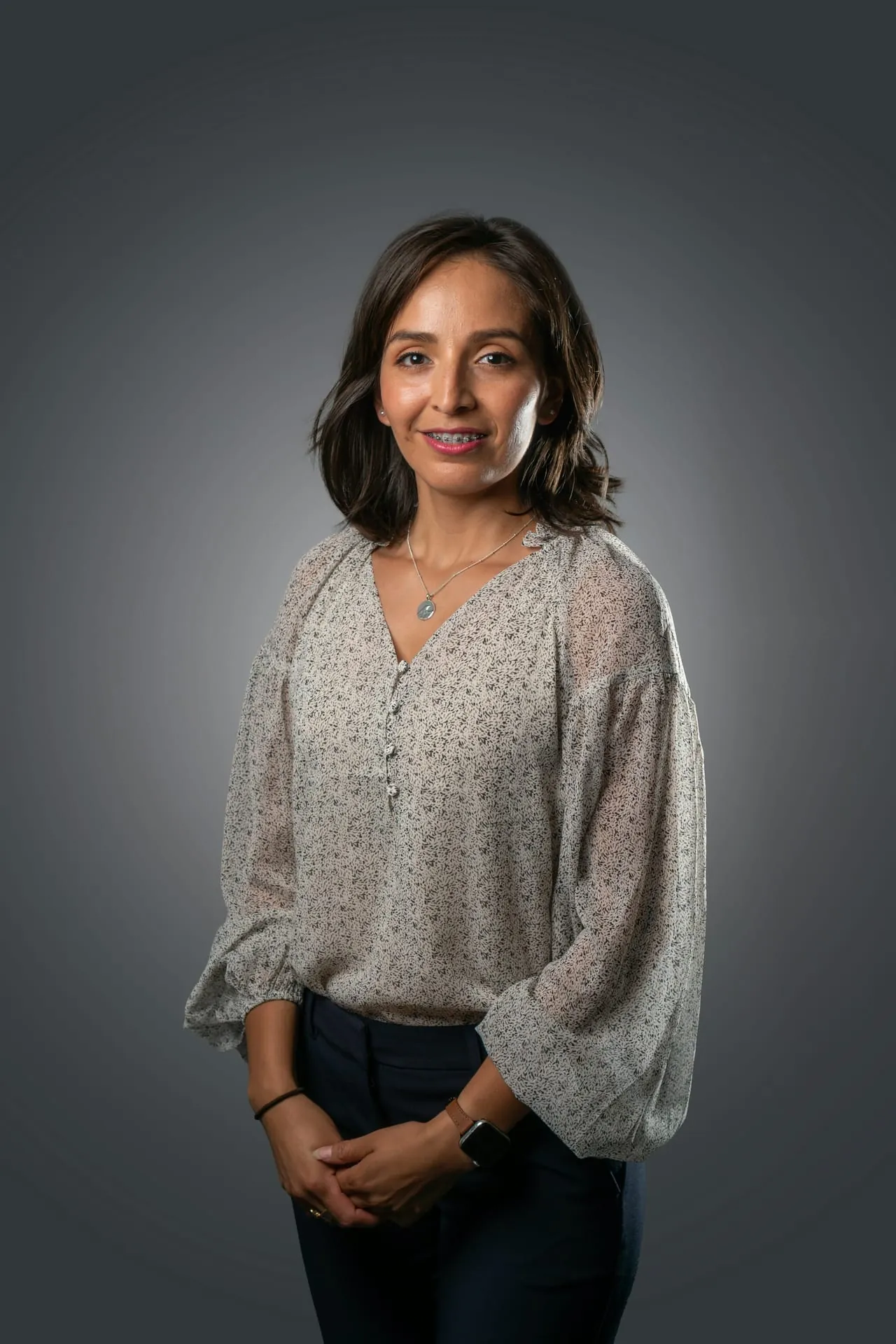 Professional woman headshot floral blouse dark bg