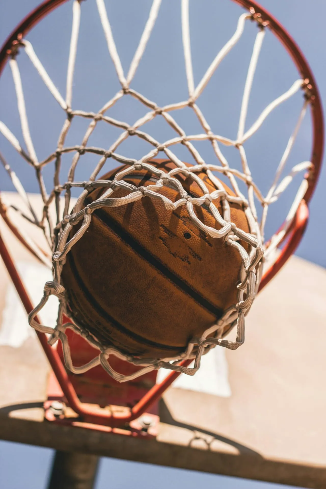 Basketball worn ball through outdoor hoop alt